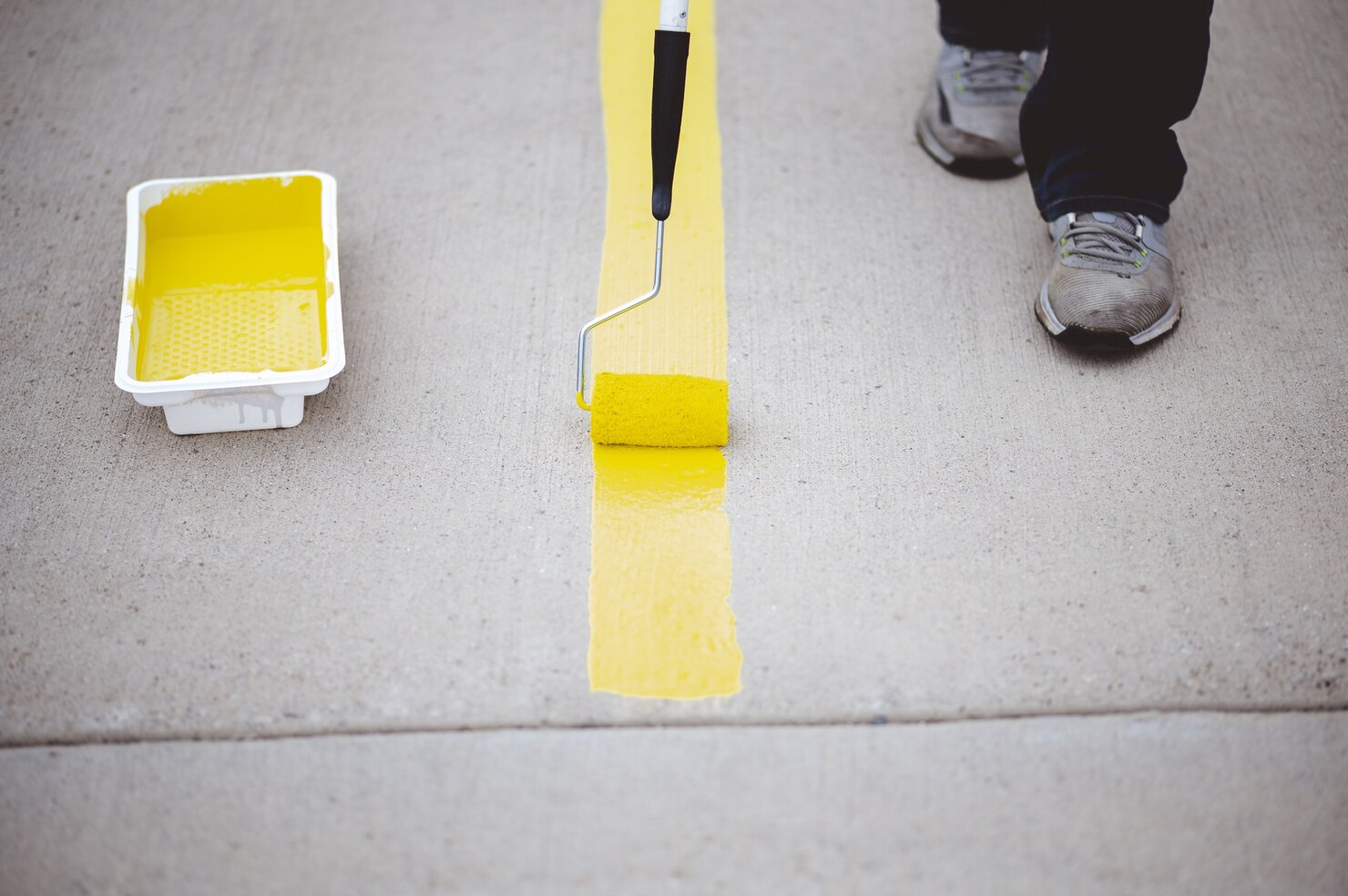 view person repainting parking lines asphalt parking lot with yellow paint 181624 17777